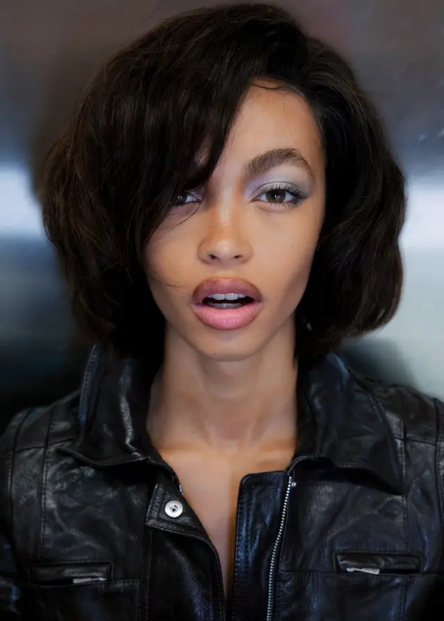 Close portrait of a woman with a dark bob and a black leather jacket.